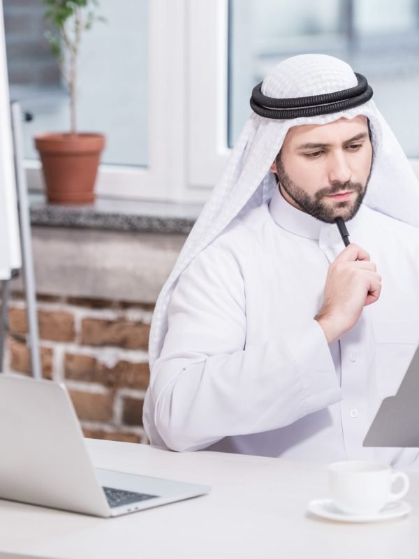 Arabian businessman looking at folder and thinking in office Arabian businessman looking at folder and thinking in office